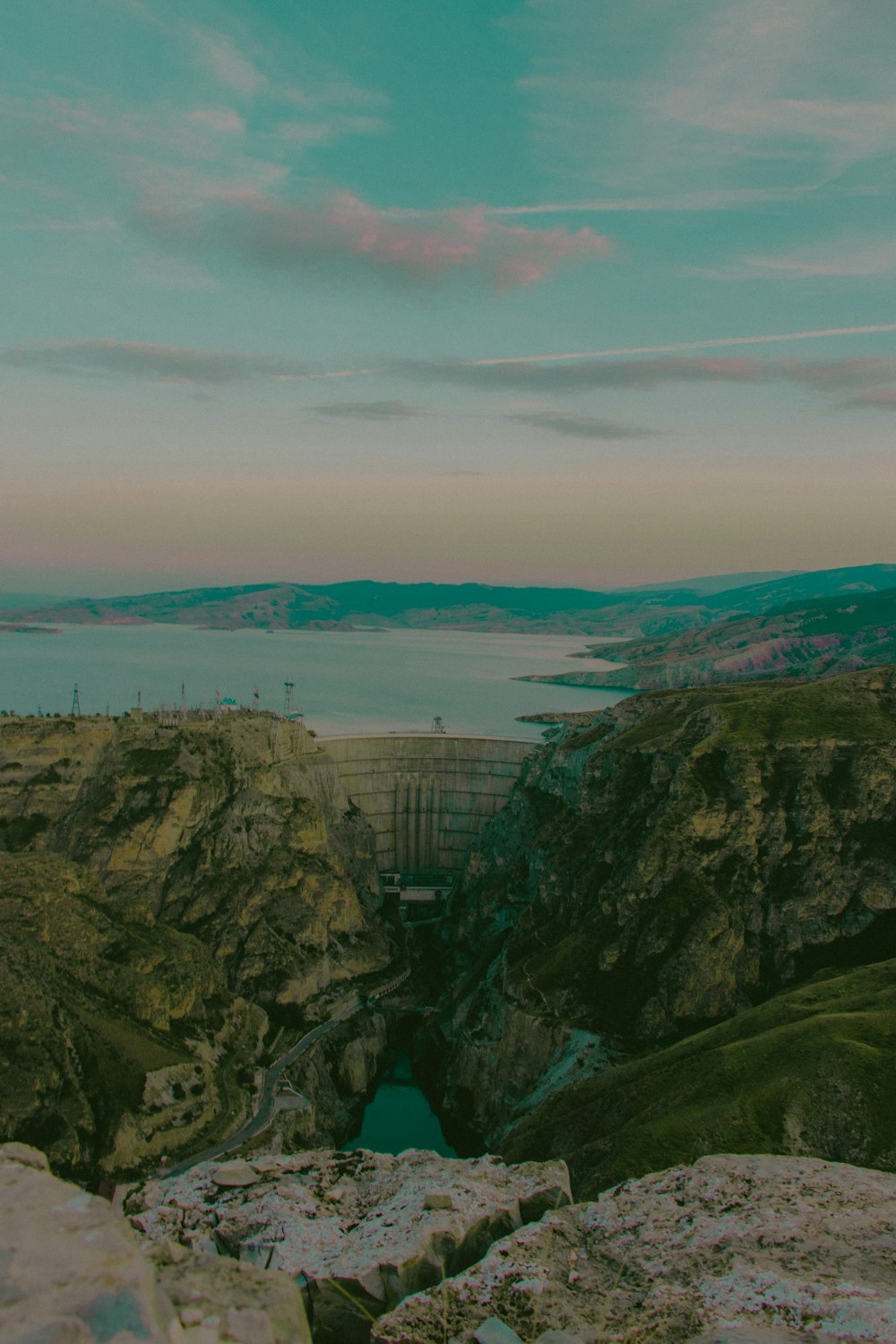 a man standing on top of a mountain next to a river