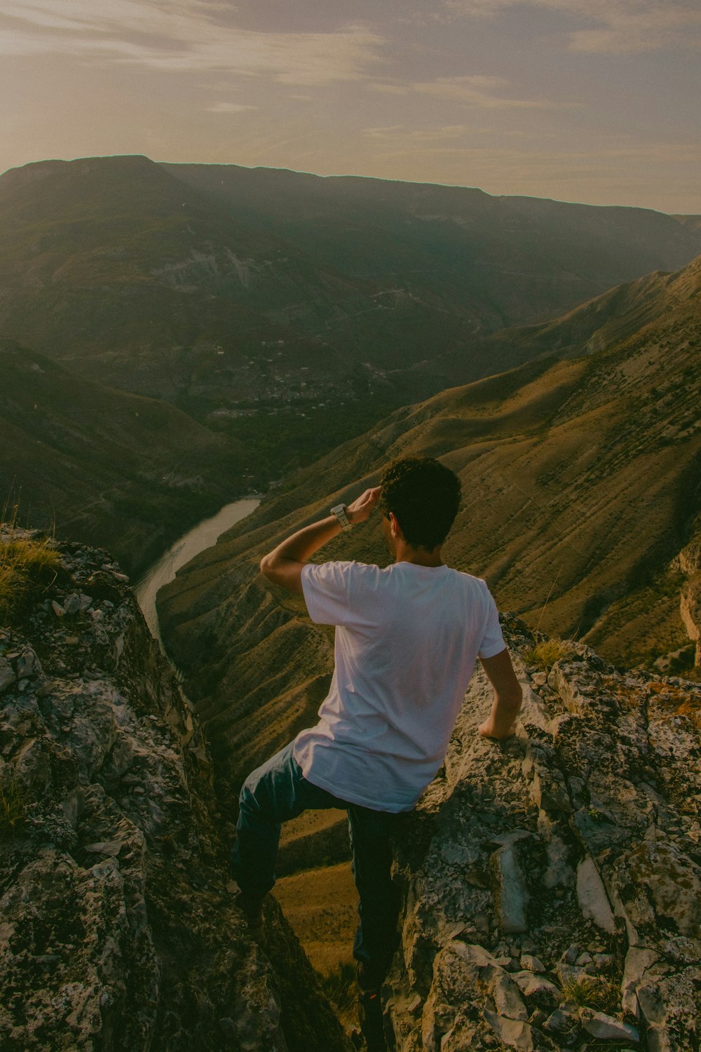 a man sitting on top of a rock cliff