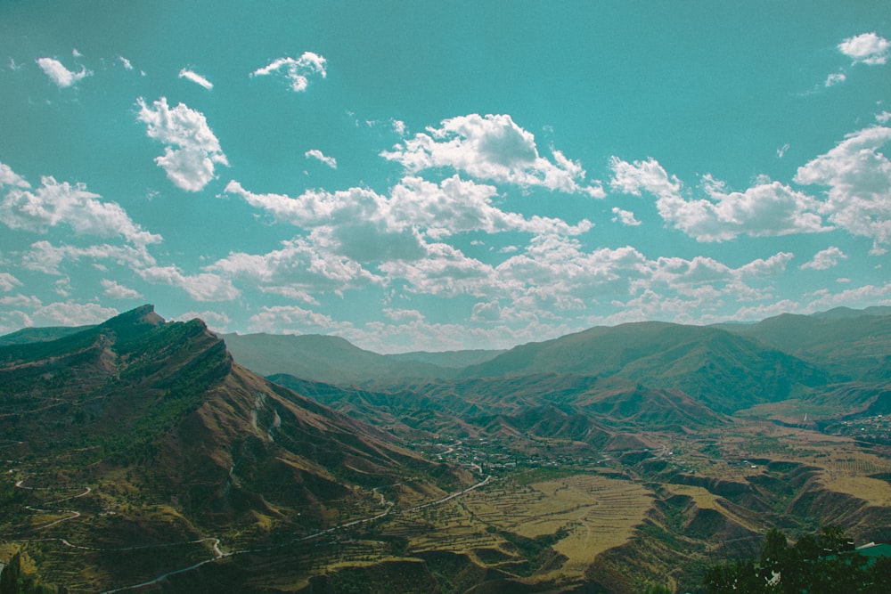 a scenic view of a valley with mountains in the background