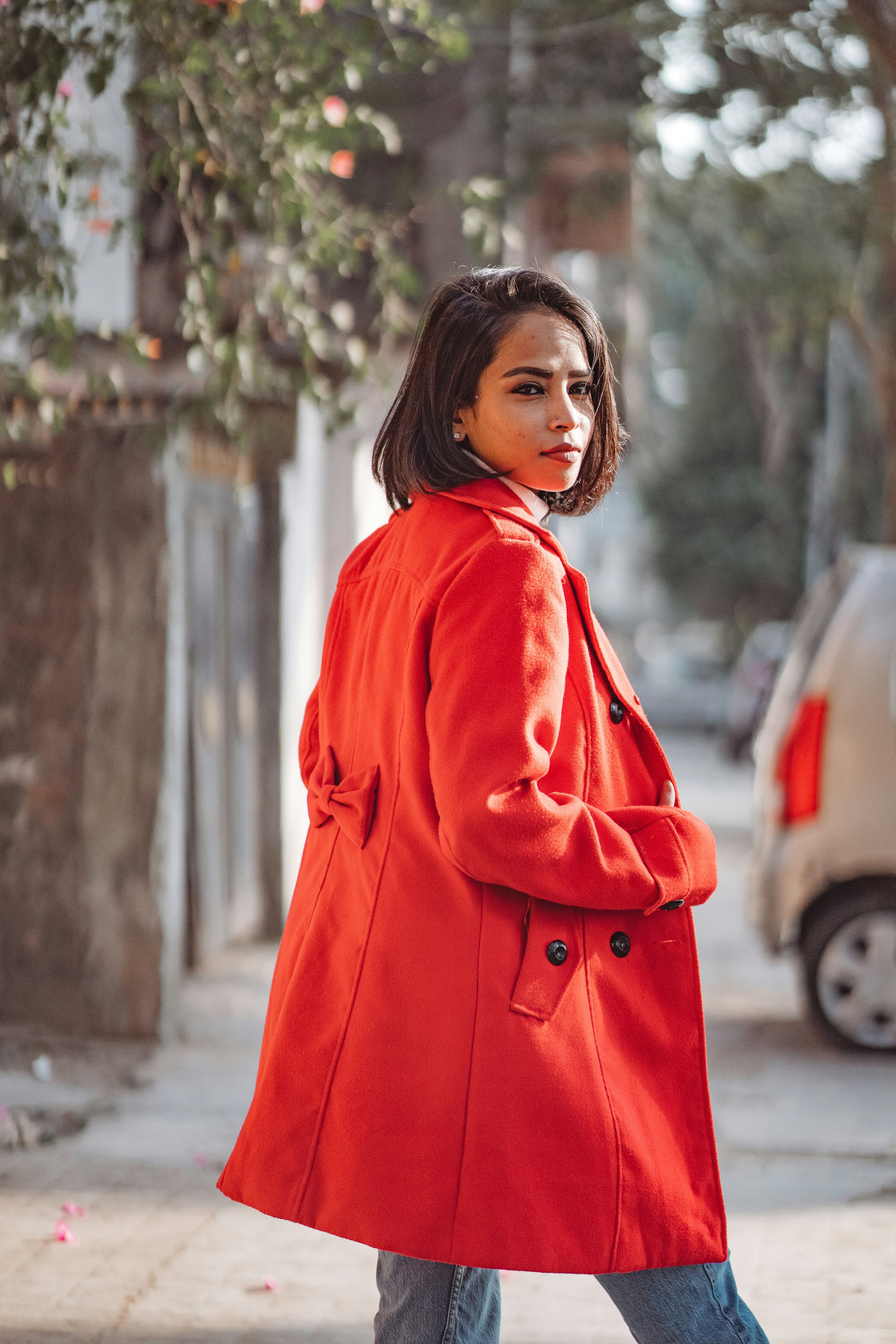 a woman in a red coat is walking down the street
