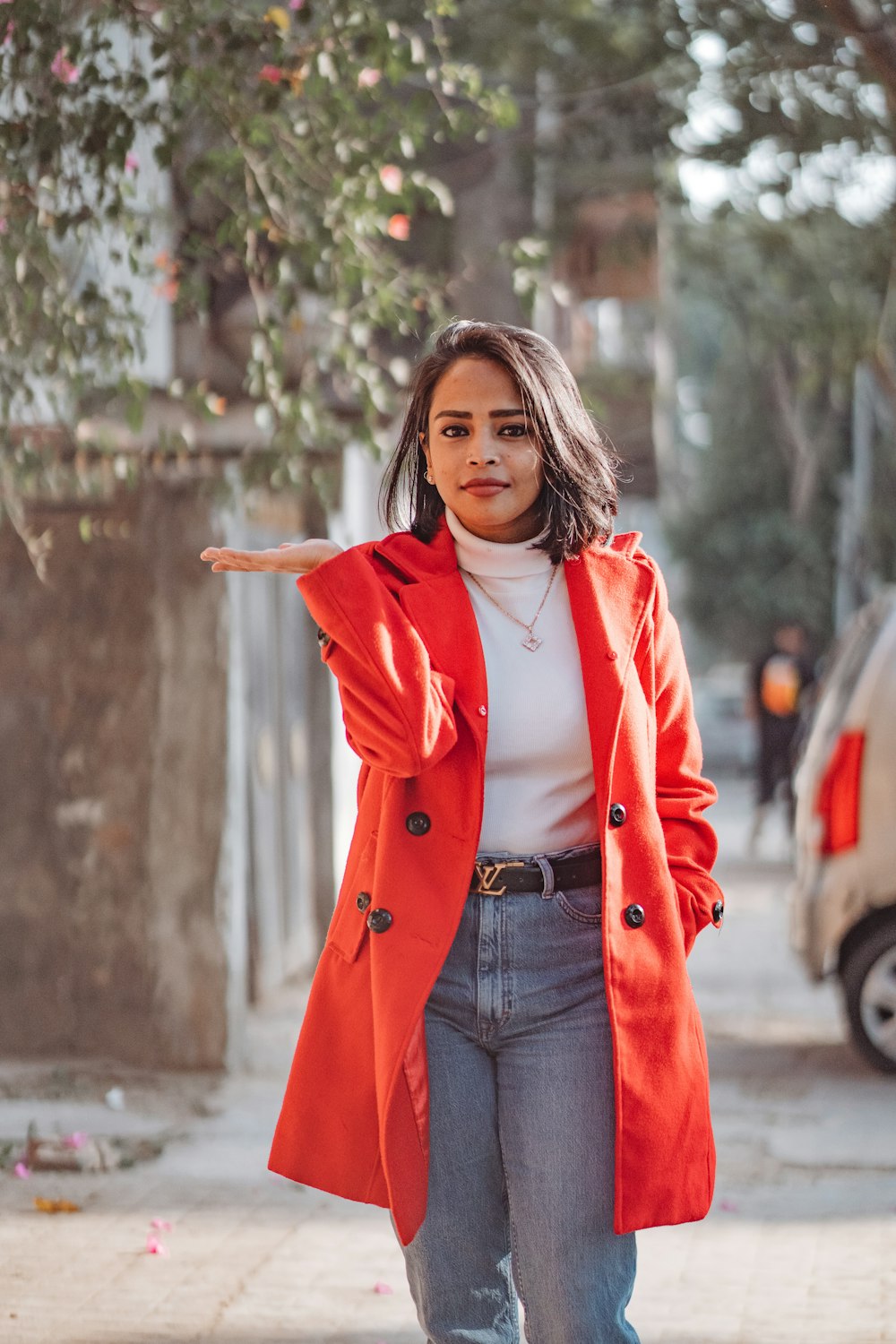 a woman in a red coat pointing at something