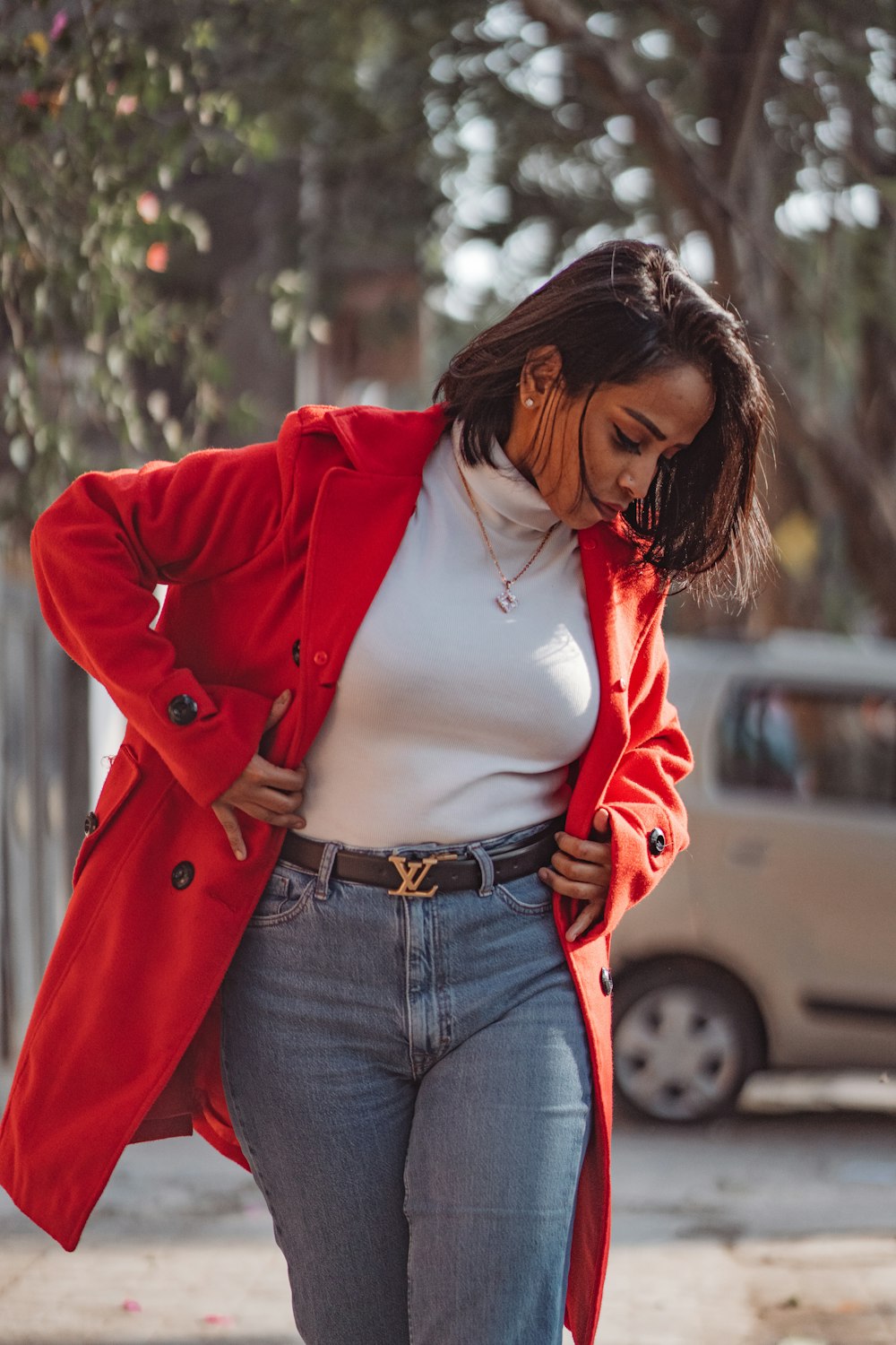 a woman in a red coat is walking down the street