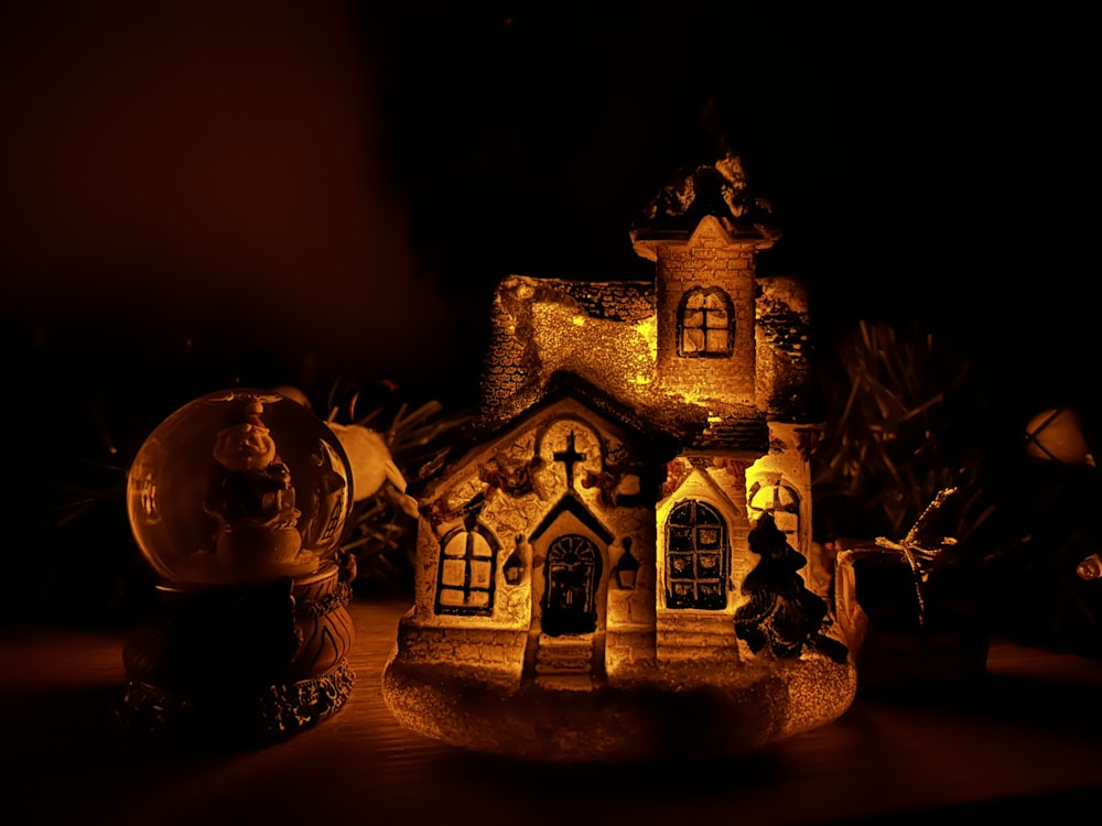 a lit up house with a clock on the front of it