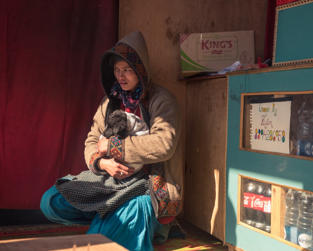 a woman sitting on the floor with a dog in her lap