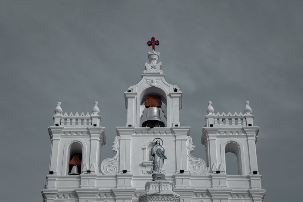 a church steeple with a bell and a statue on top