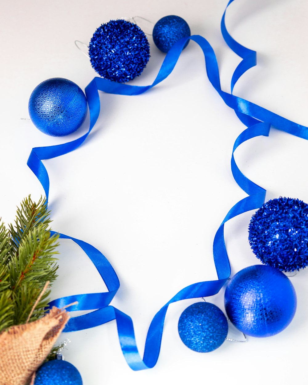 a blue christmas ornament with blue balls and a blue ribbon