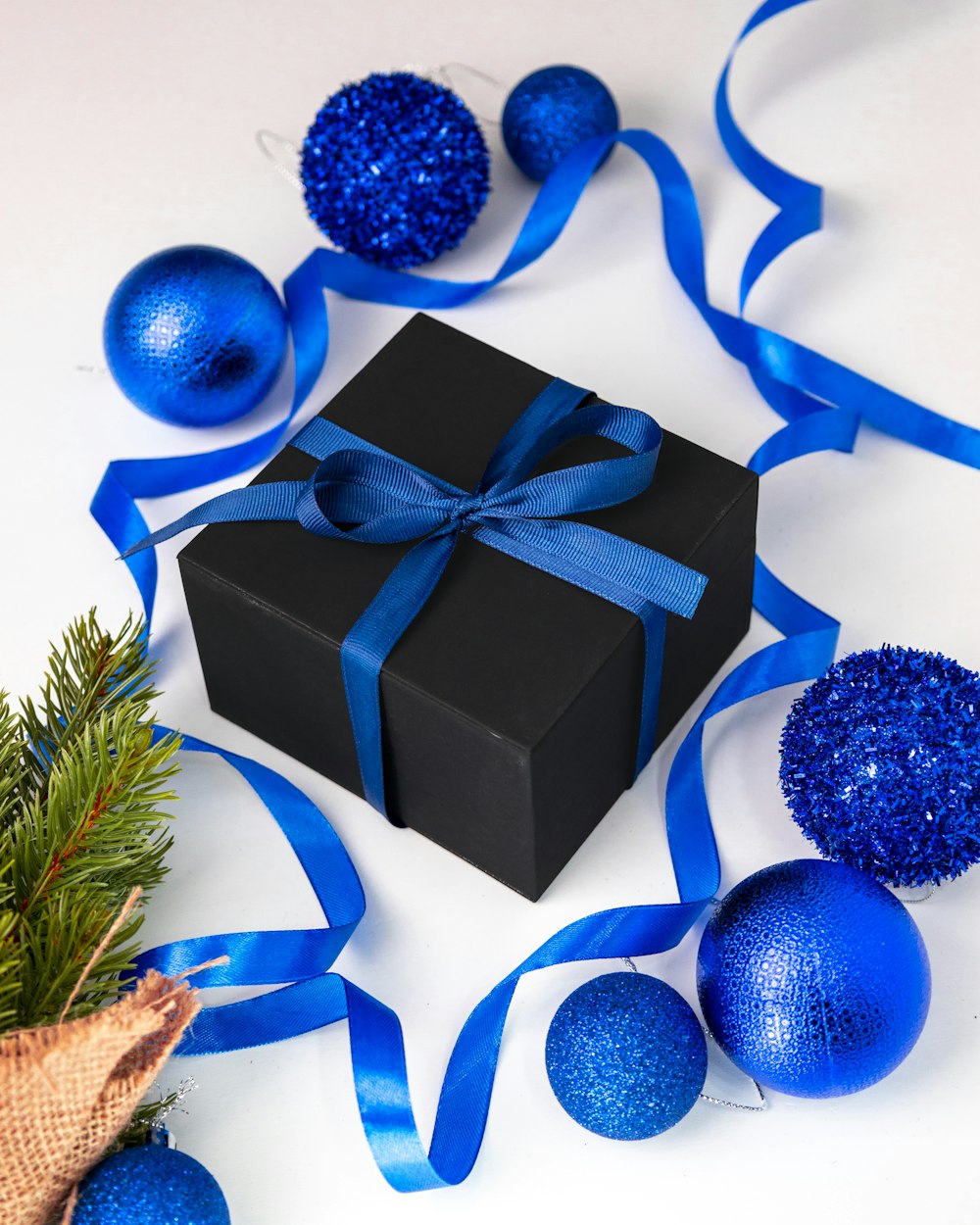 a black box with a blue ribbon and ornaments around it