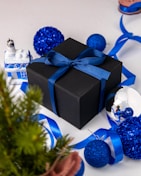 a black box with a blue ribbon and decorations around it