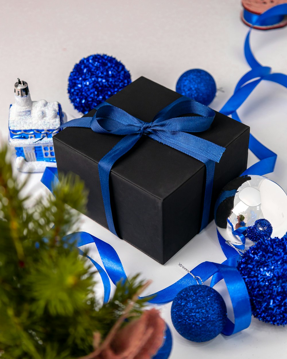 a black box with a blue ribbon and decorations around it