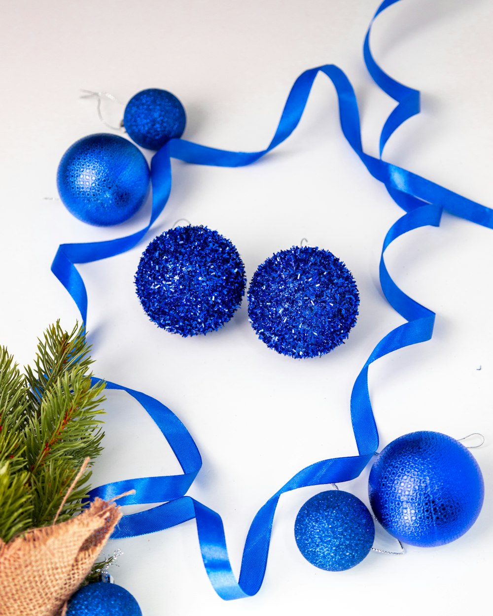 Un ornamento di Natale blu e due palline blu su uno sfondo bianco