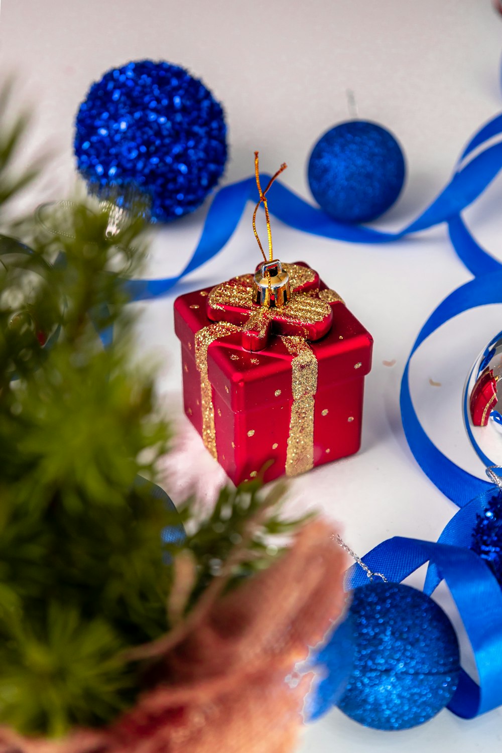 a christmas ornament with a red present on it