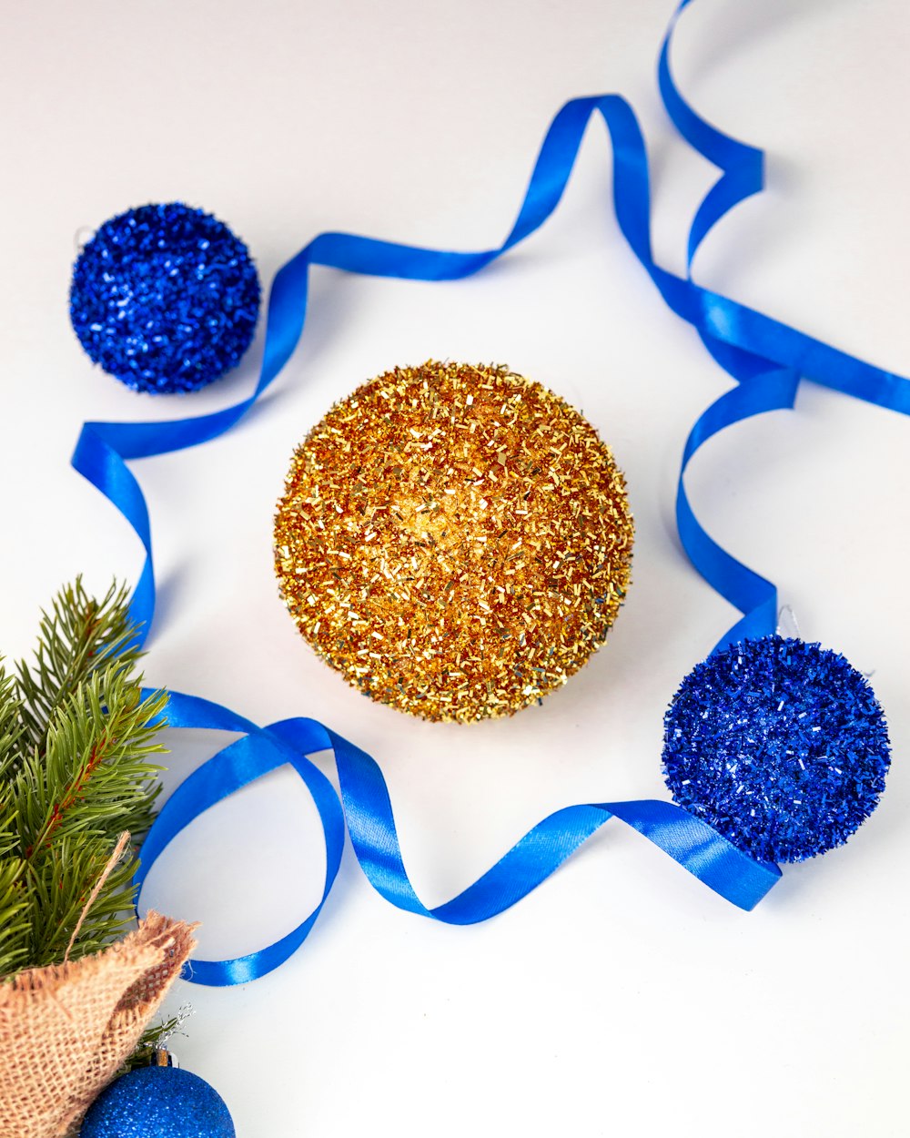 uma decoração de Natal azul e dourada com uma fita azul