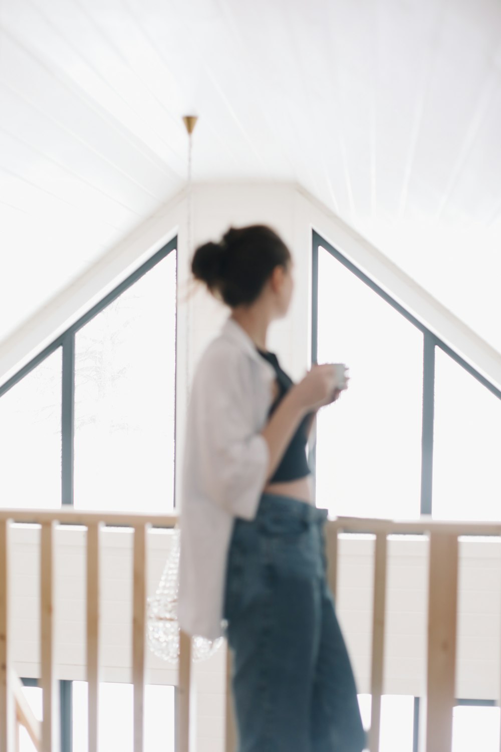 a woman standing on a balcony with a cell phone in her hand