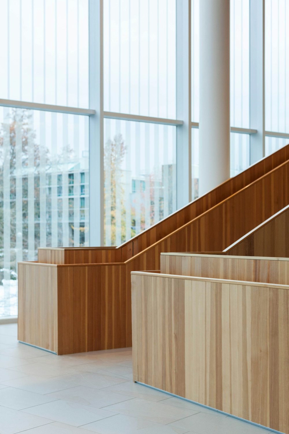 an empty lobby with wooden benches and windows