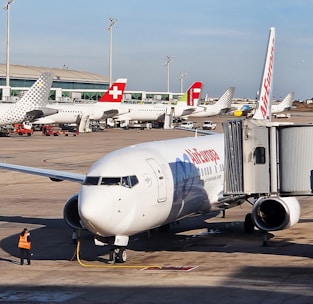 A warm customer service interaction at an airport booking counter with PeruAir Barcelona branding.