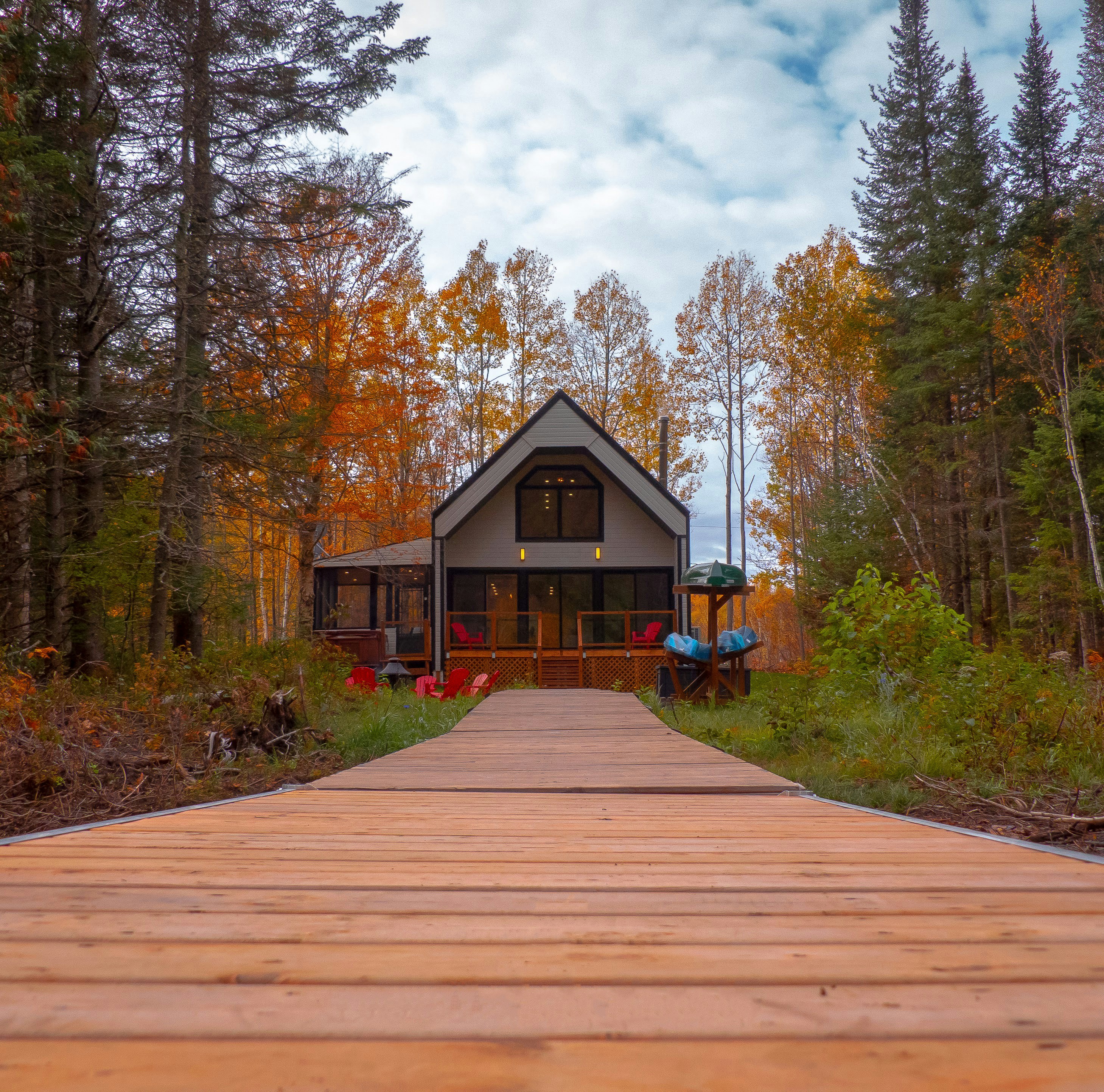 a wooden walkway leading to a house in the woods
