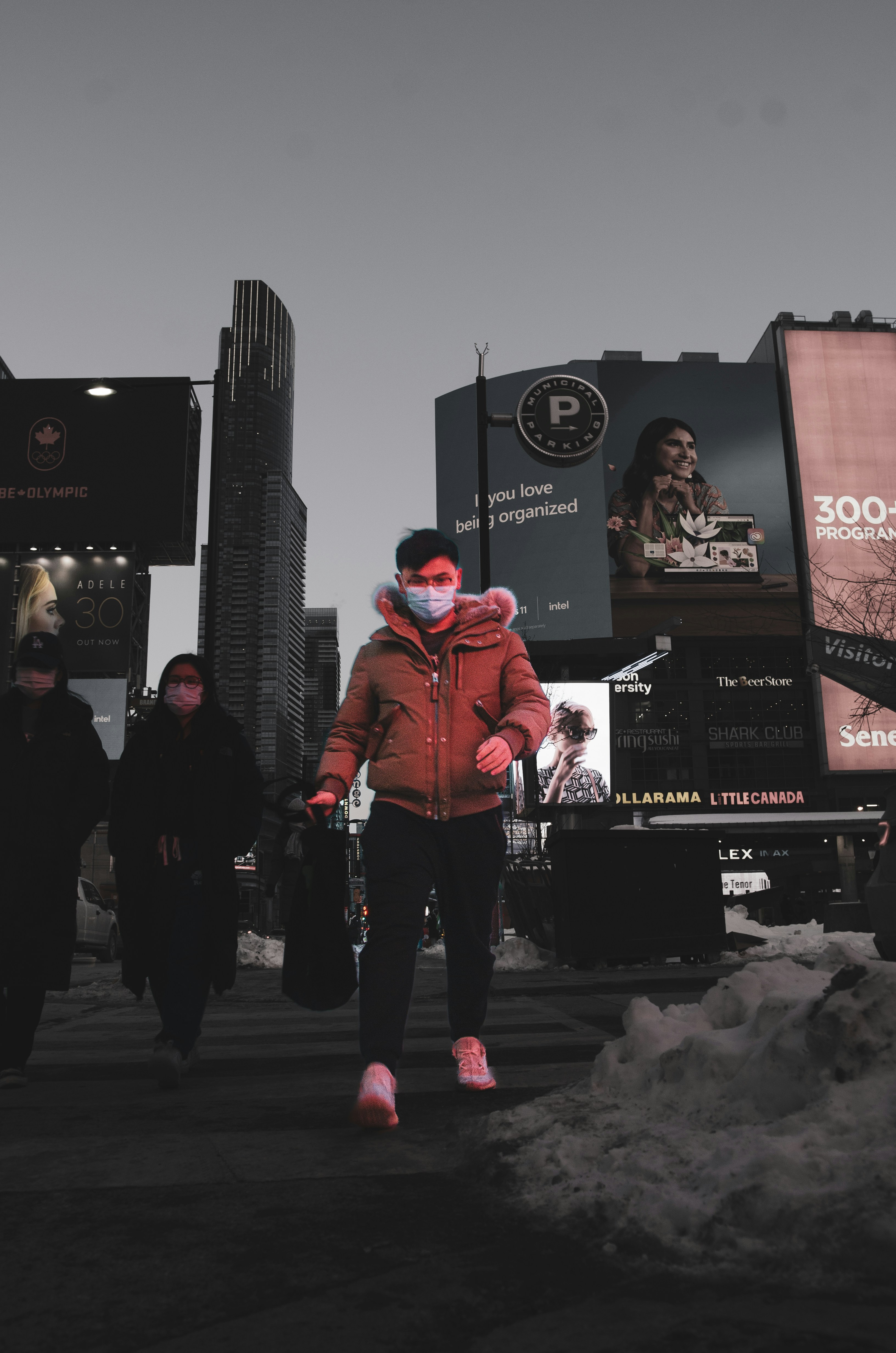 Seorang wanita mengenakan masker wajah berjalan di jalan