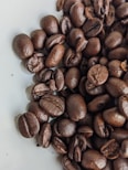A close-up of roasted coffee beans with a rich, dark brown color and glossy texture.