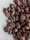 A close-up of roasted coffee beans with a rich, dark brown color and glossy texture.