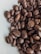 A close-up of roasted coffee beans with a rich, dark brown color and glossy texture.