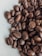 A close-up of roasted coffee beans with a rich, dark brown color and glossy texture.