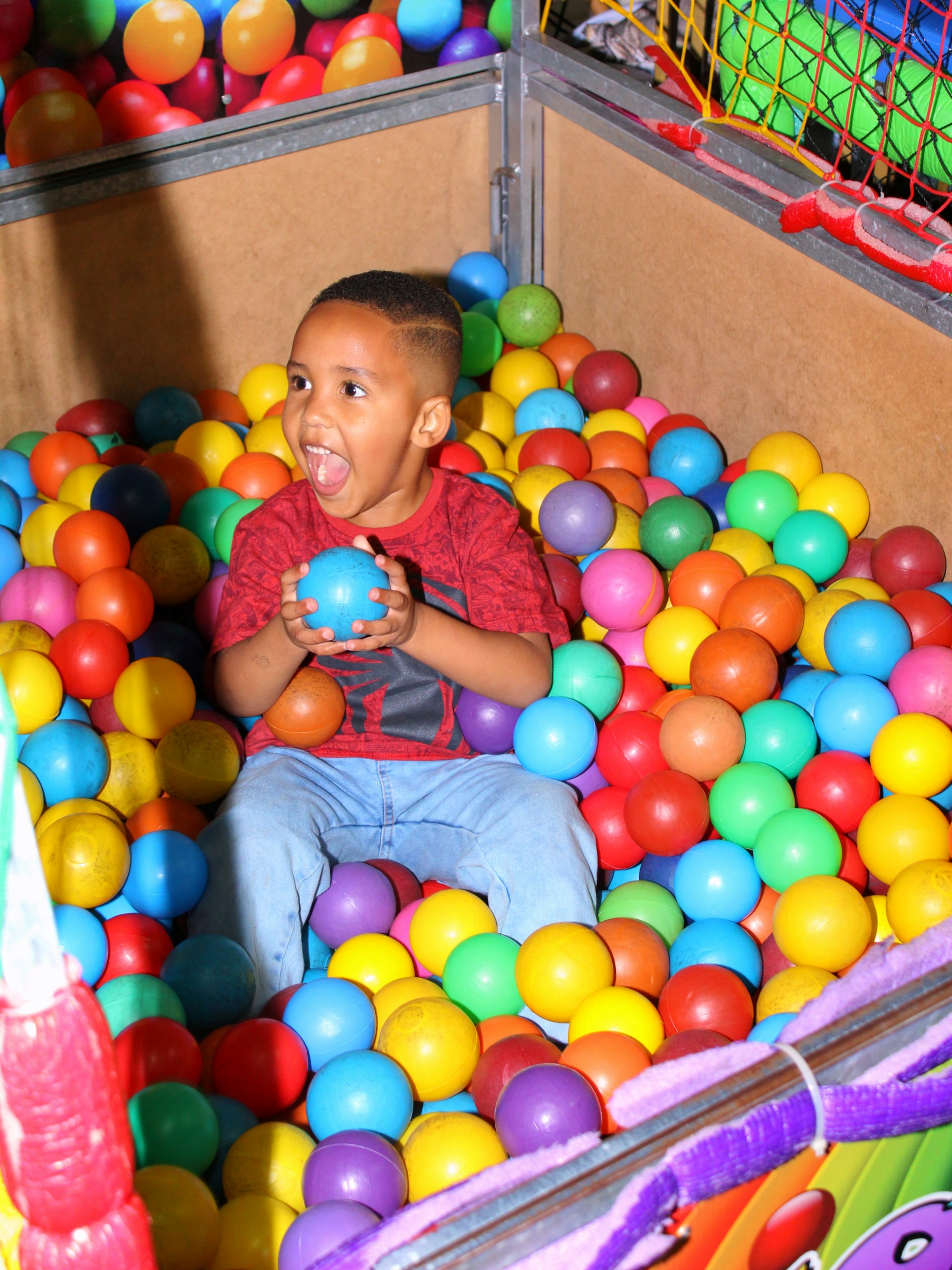 Children seated on a colorful therapy ball and a small trampoline, laughing and building coordination while engaged in playful therapy.