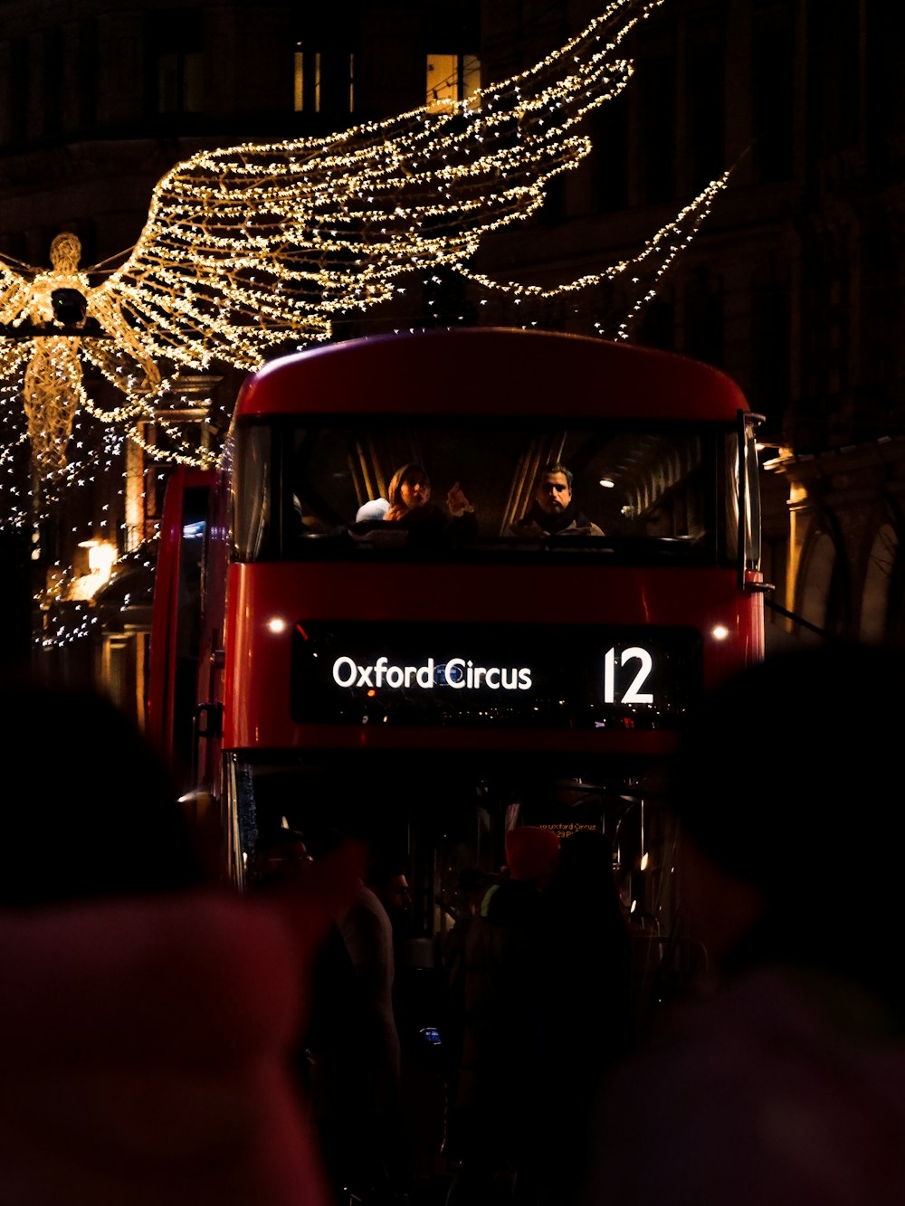 a red double decker bus driving down a street