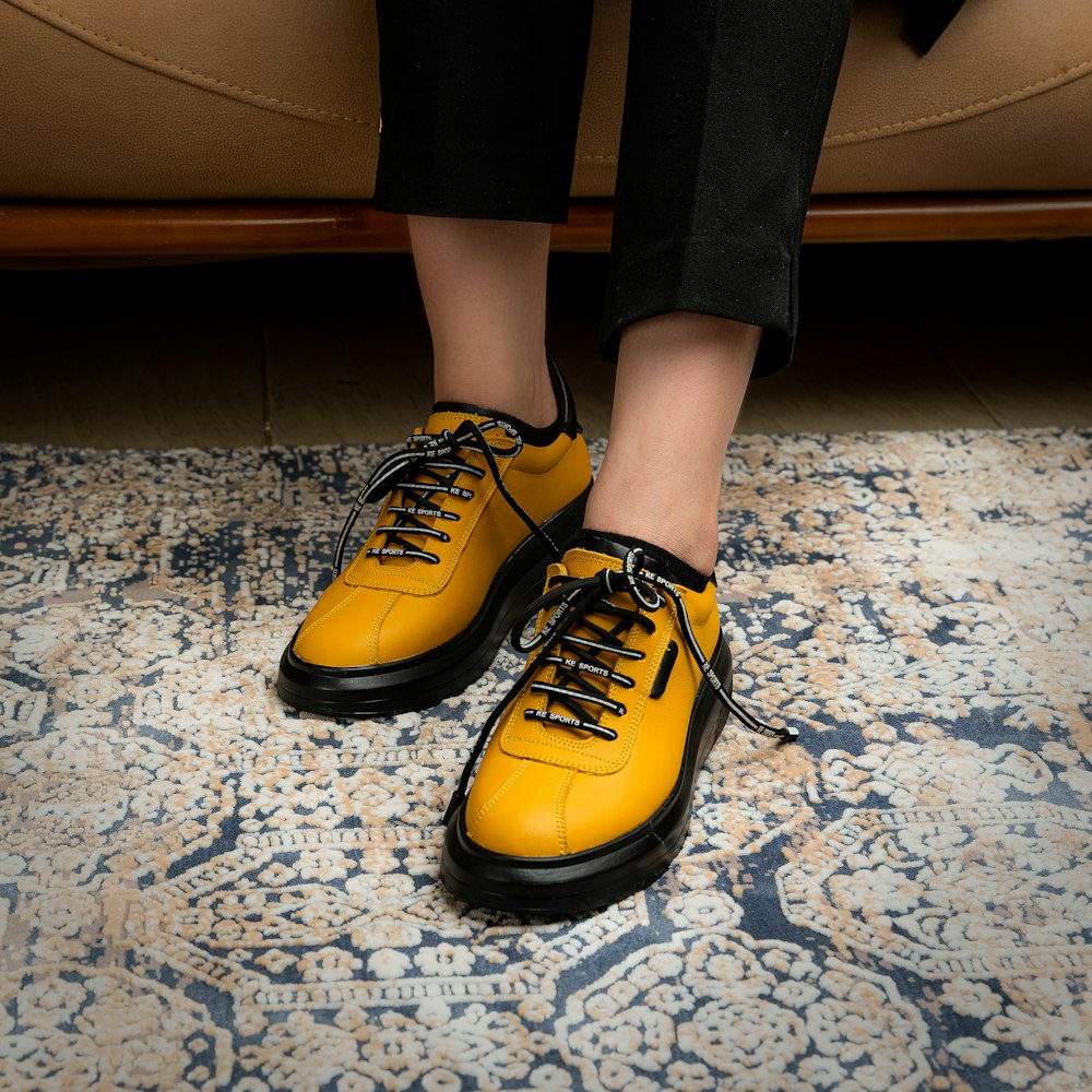 a person sitting on a couch wearing yellow shoes