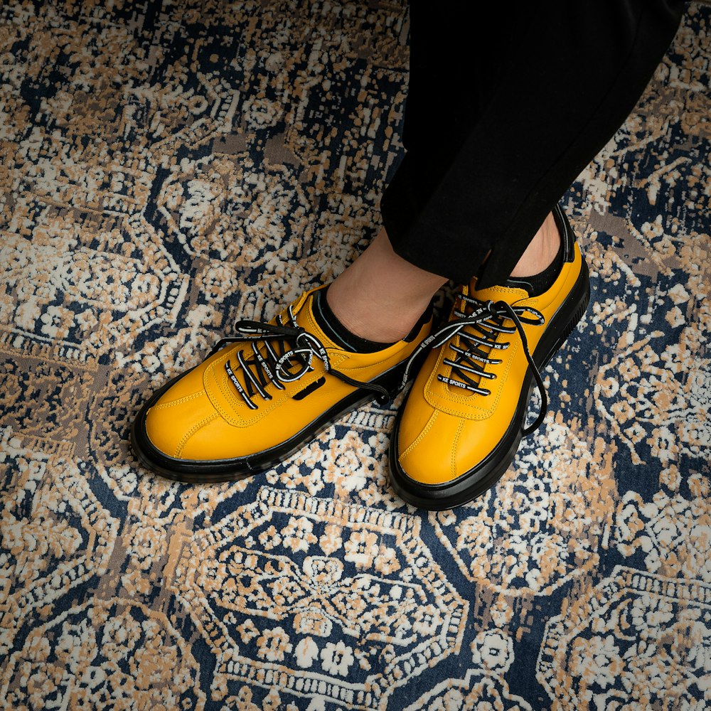 a person standing on a rug wearing yellow shoes