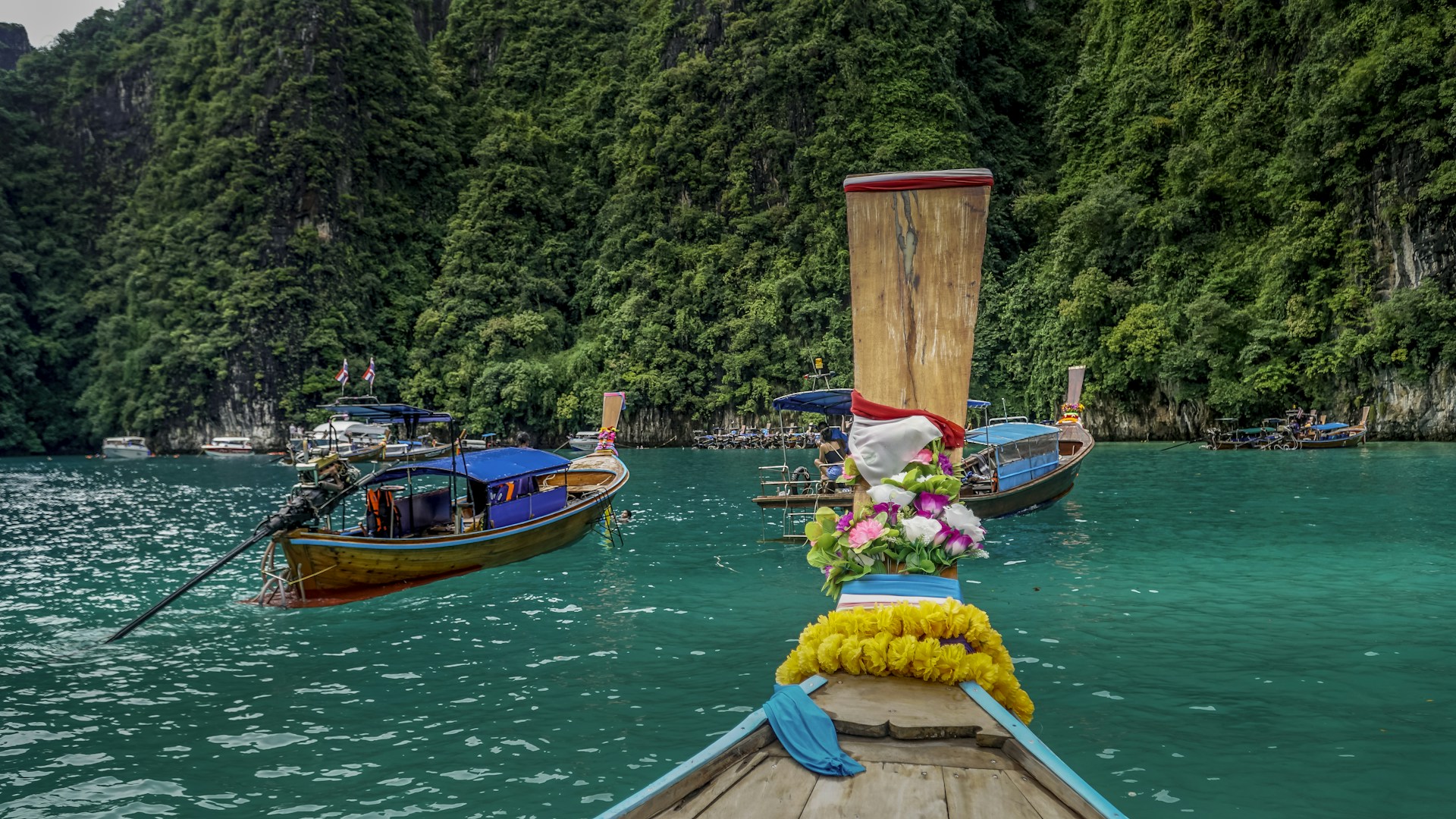 a row of boats floating on top of a body of water