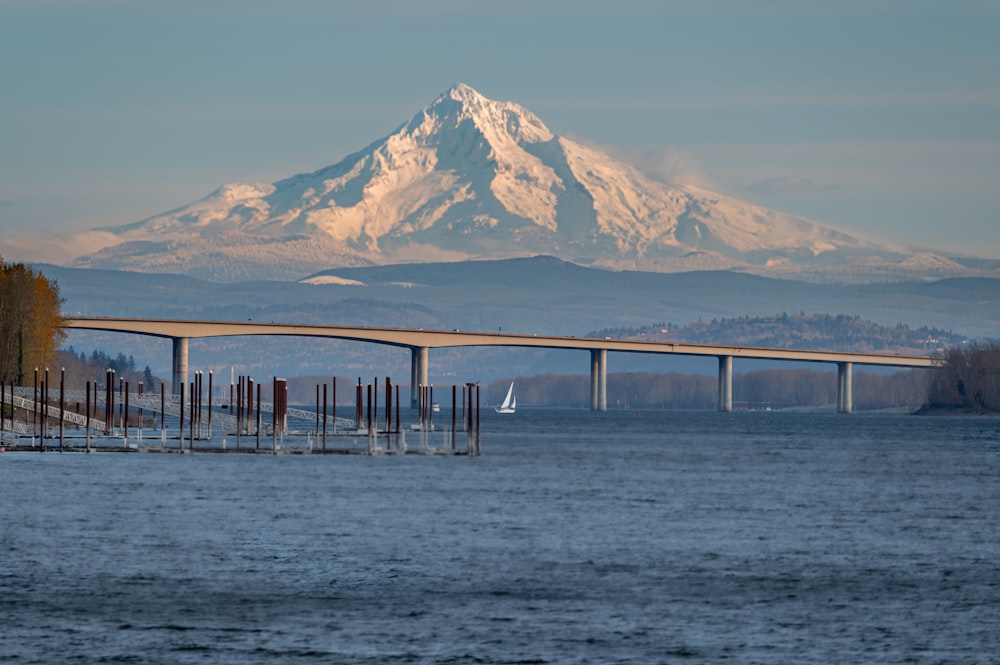 a bridge over a body of water with a mountain in the background