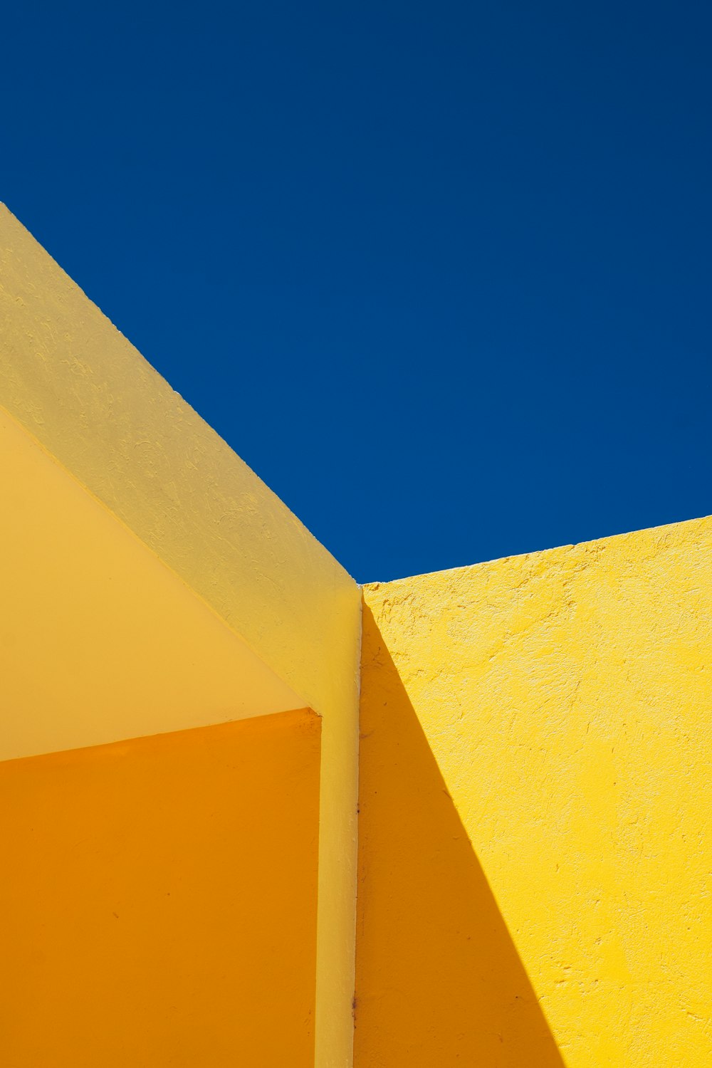 a yellow building with a blue sky in the background