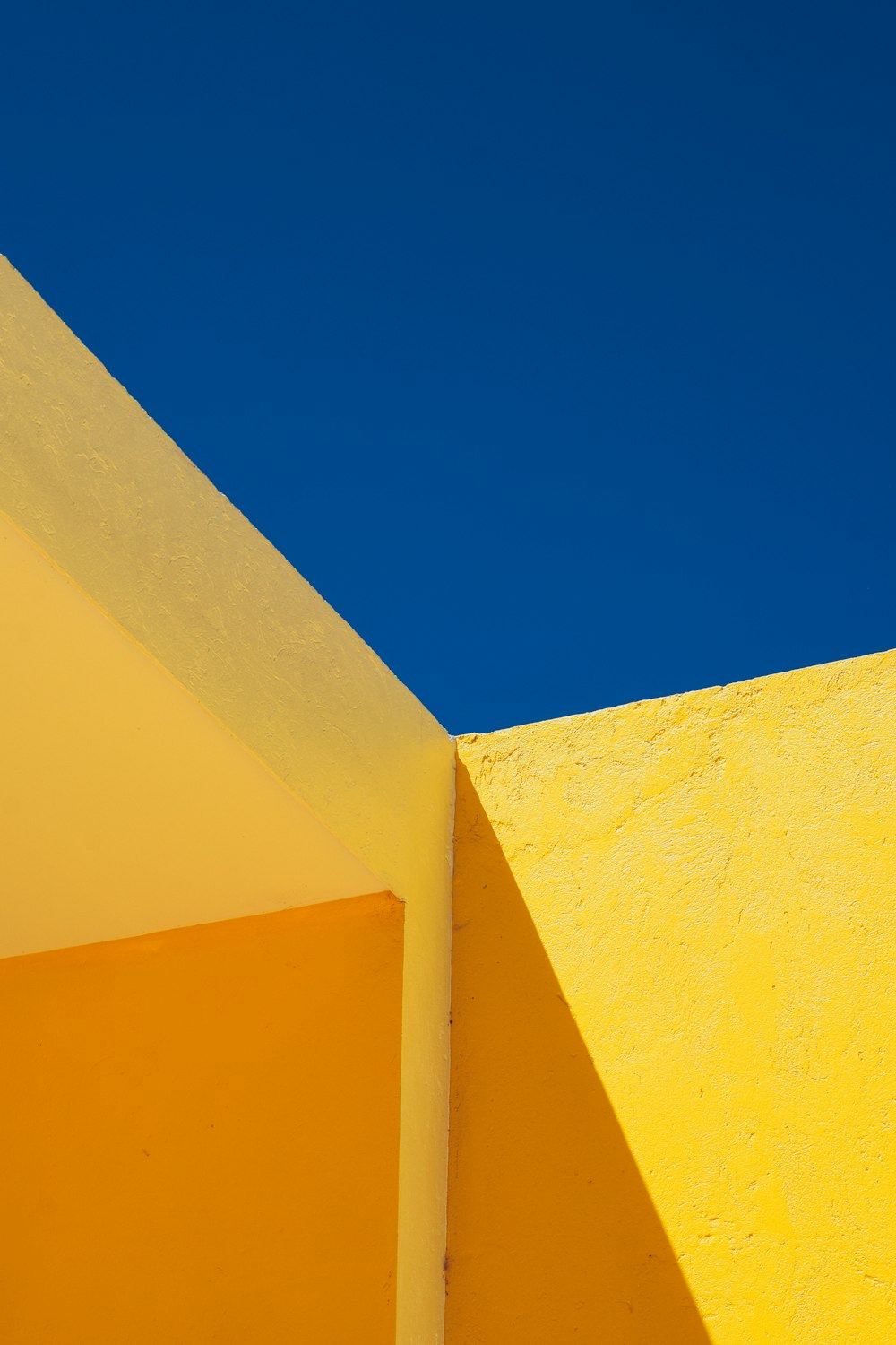 um edifício amarelo com um céu azul no fundo