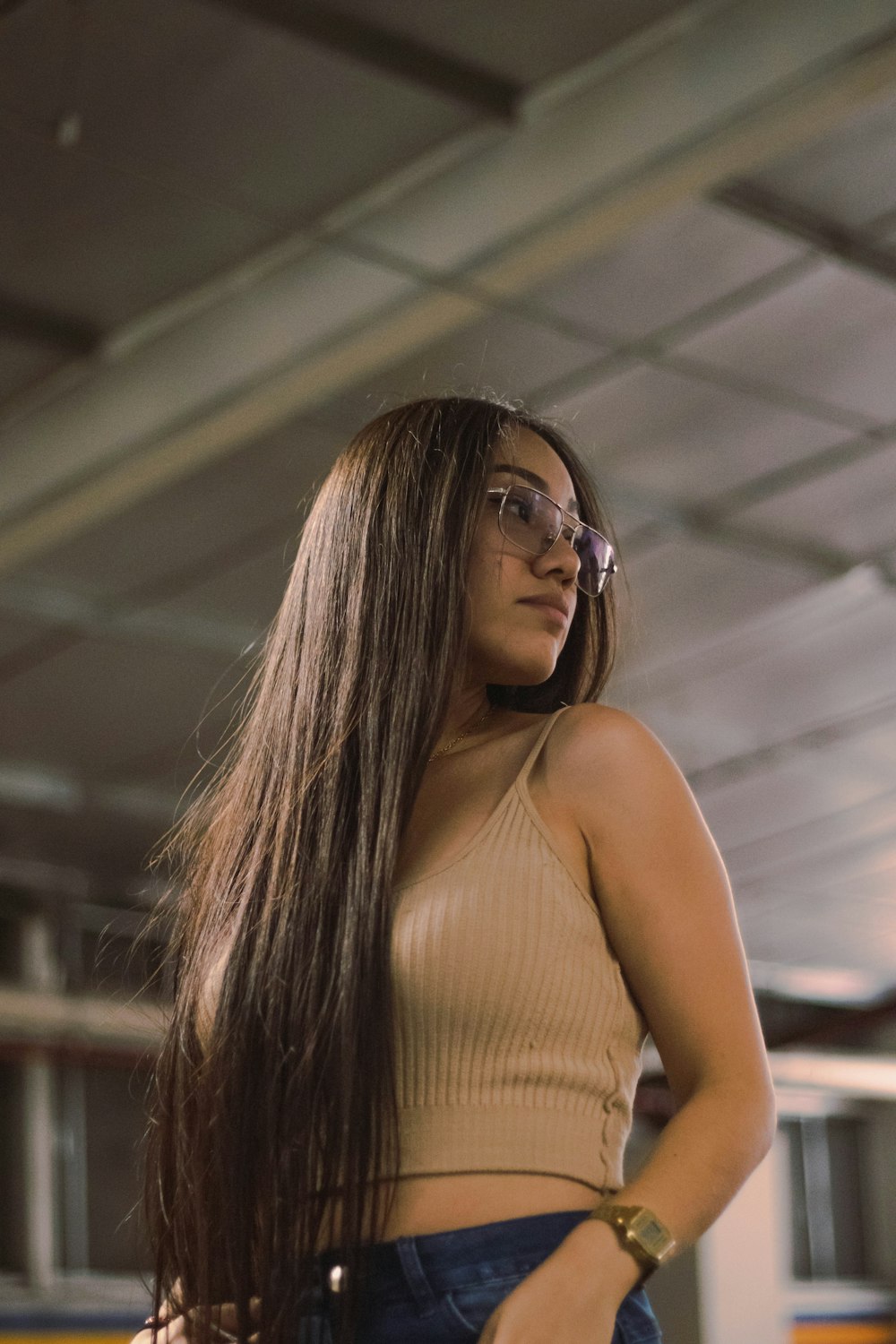 a woman with long hair standing in a train station