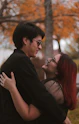 a man and a woman embracing in a park
