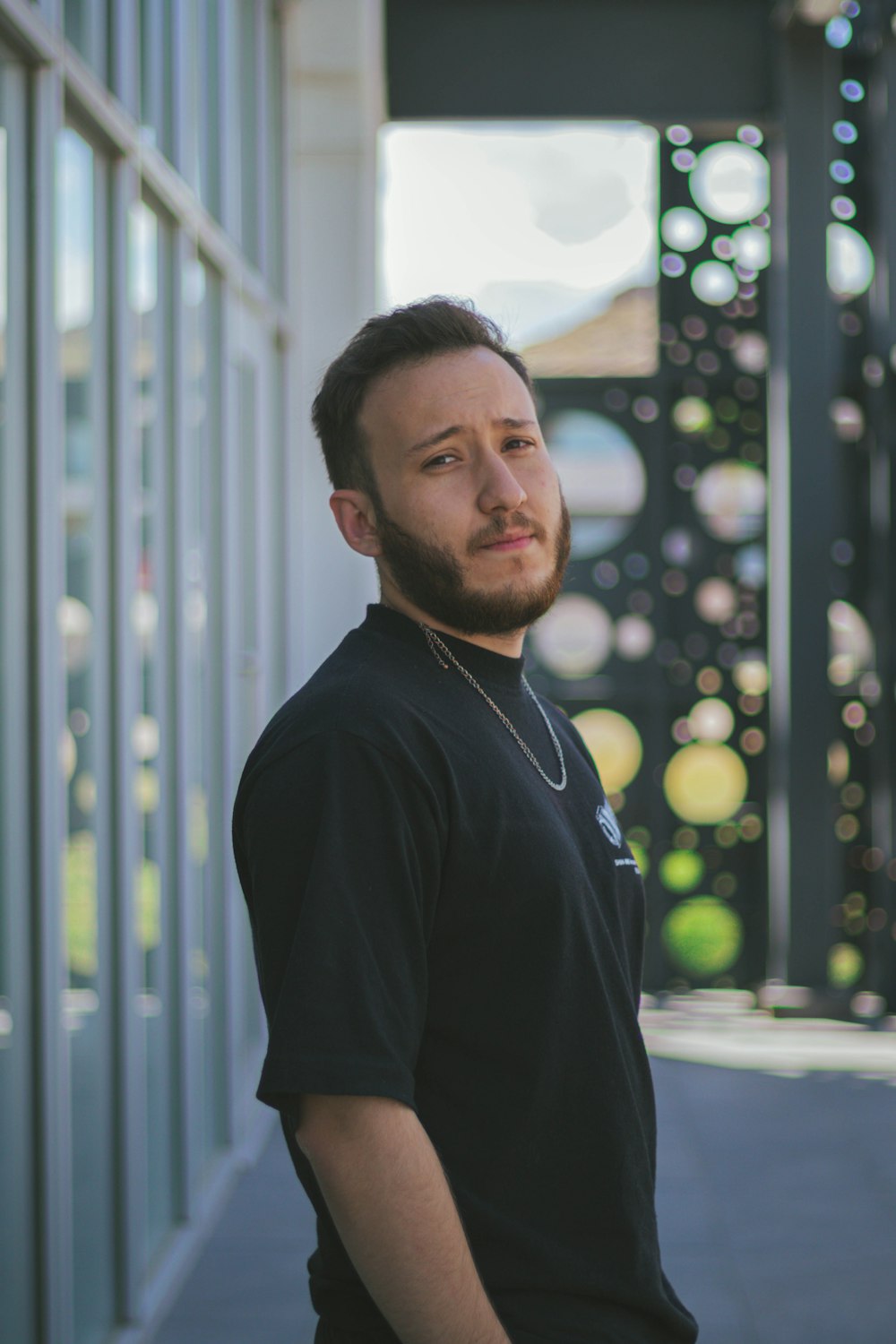 a man with a beard standing in front of a building