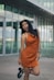 a woman in an orange dress posing for a picture