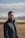 a man in a black jacket standing in a desert