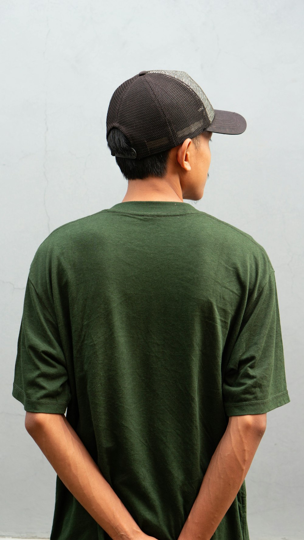 a man wearing a green shirt and a black hat