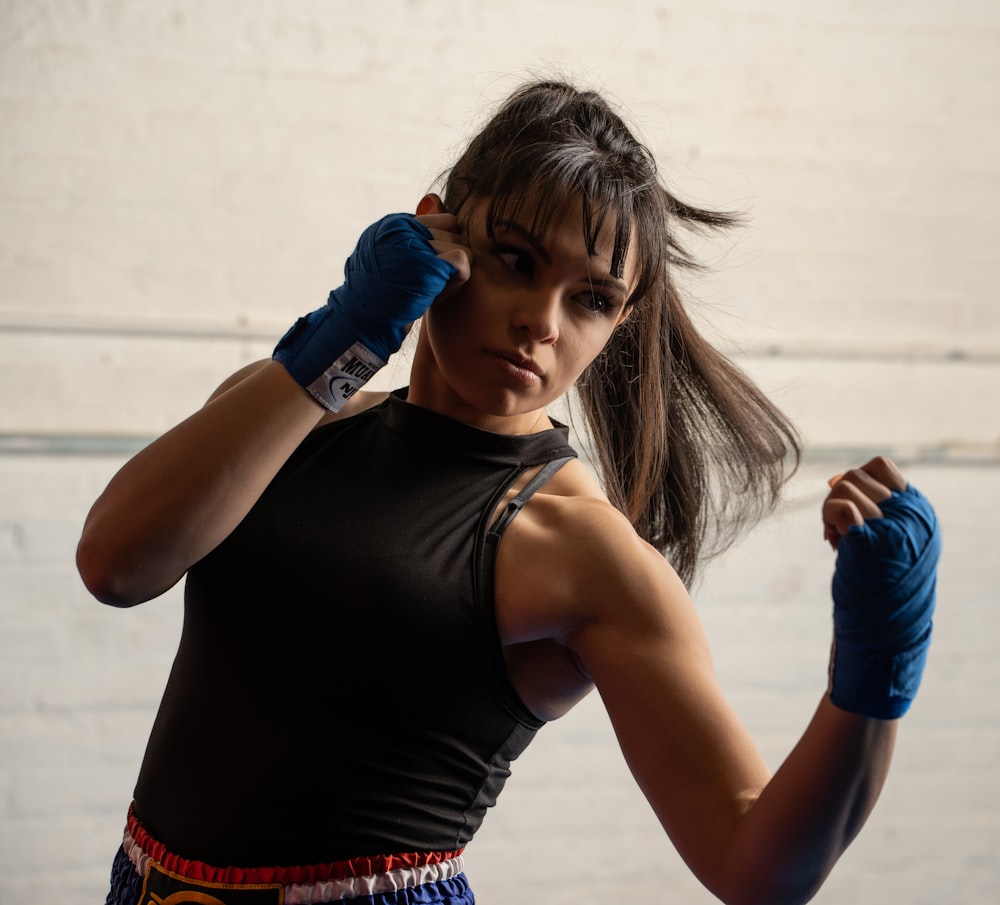 a woman in a black shirt and blue gloves