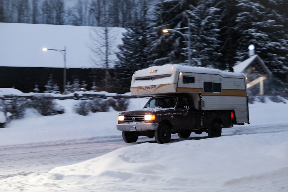 a truck pulling a camper on a snowy road