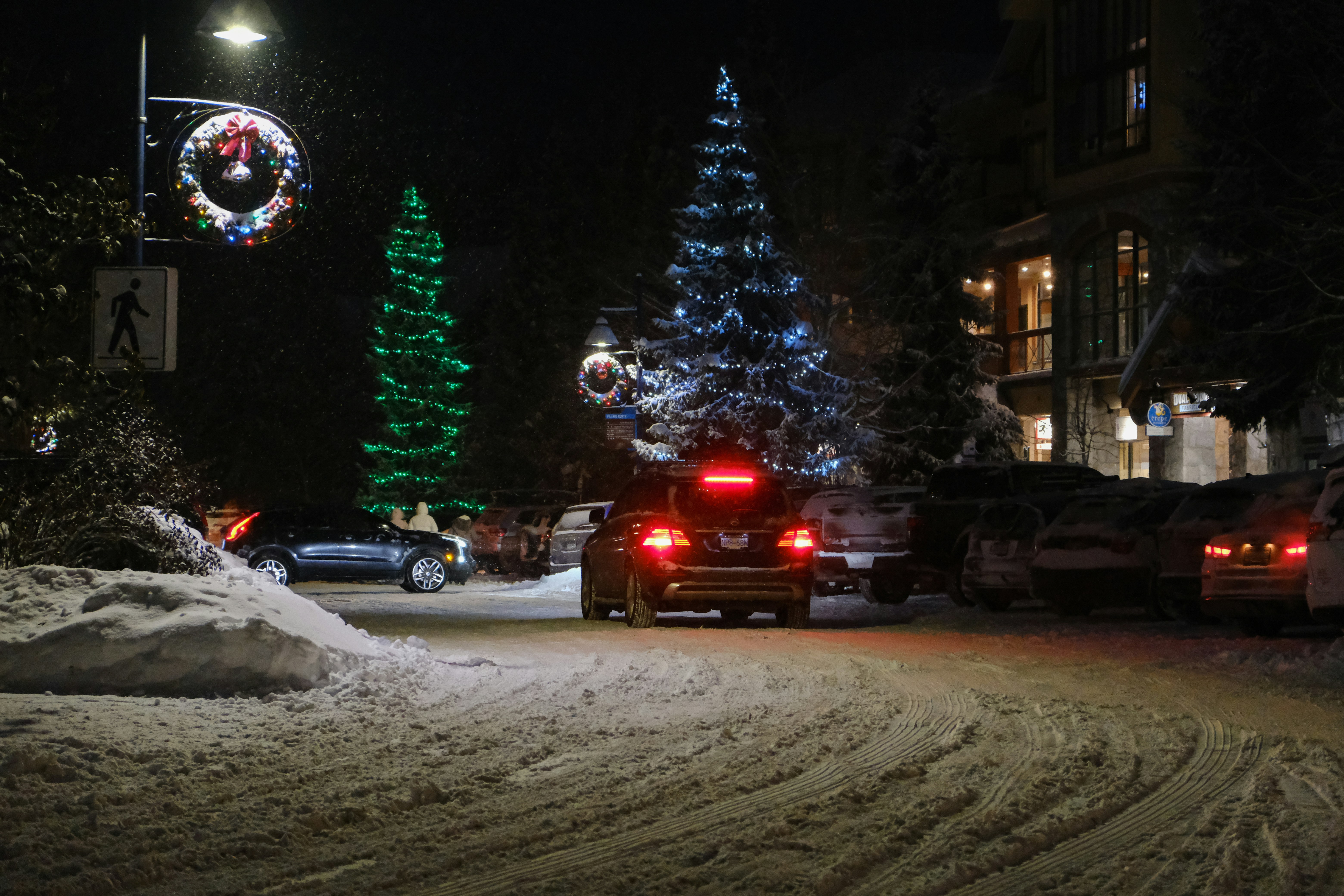 a car driving down a snow covered street at night