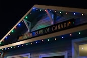 A building facade displaying 'The Royal Bank of Canada' sign, adorned with colorful string lights in blue, red, green, and yellow hues.