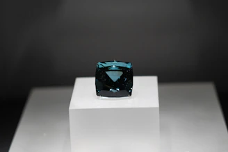 Close-up of a deep blue Ceylon sapphire with facets catching the light against a dark velvet background.