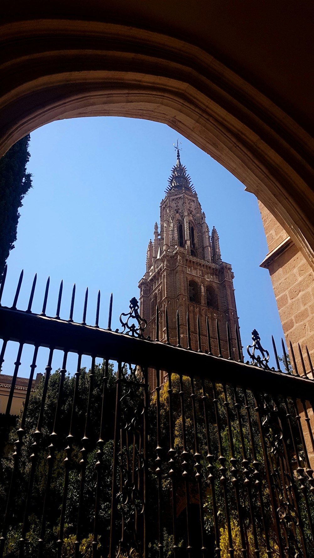 a clock tower seen through an iron fence