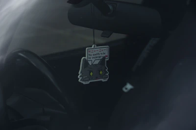 A car interior featuring a vesėja air freshener clipped to the air vent.