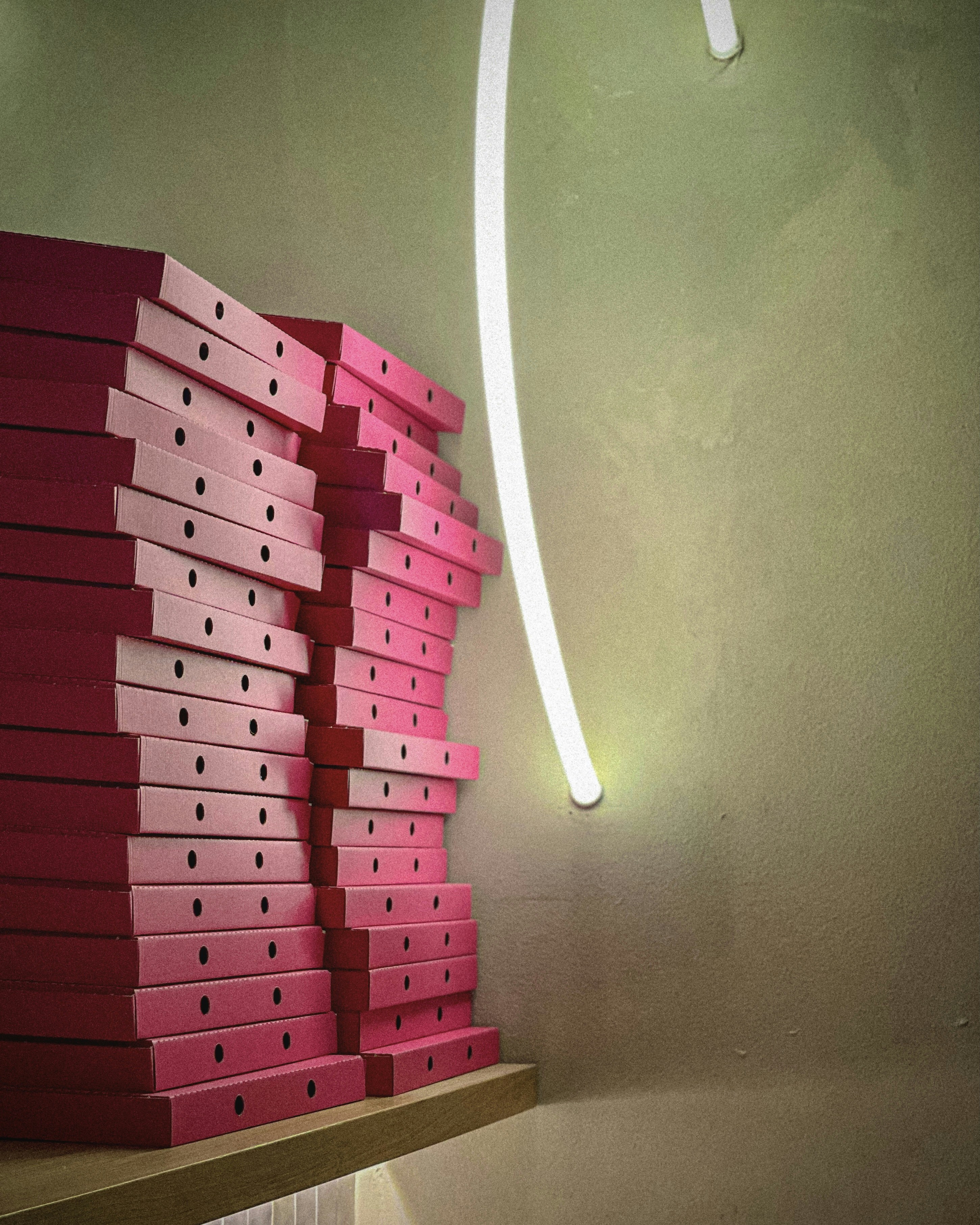 A stack of pink boxes sitting on top of a wooden shelf photo – Free ...