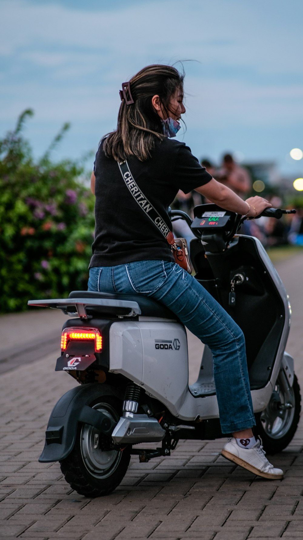 a woman riding on the back of a scooter