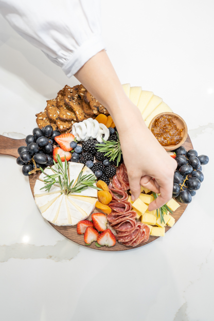 a person reaching for a platter of food