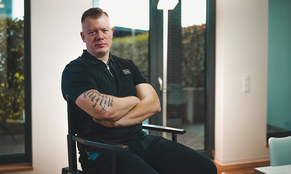 a man sitting in a chair with his arms crossed